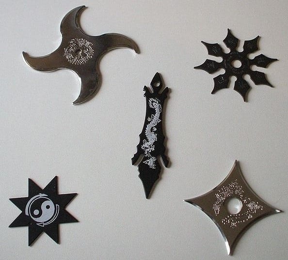 A photograph of several steel shuriken (throwing blades) arranged on a surface.