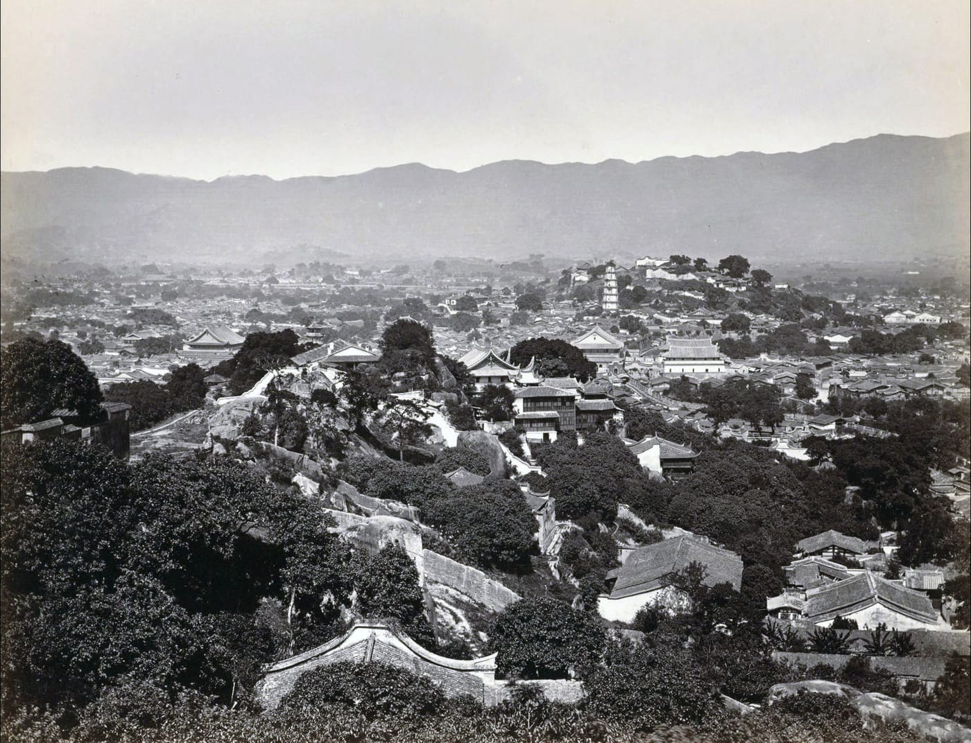 A panoramic black-and-white photograph of Fuzhou, Fujian, China, around 1870, the city spread below pagoda-topped hills.