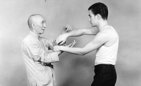 A 1958 black-and-white photograph of Ip Man with his young student Bruce Lee.